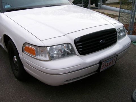 1999 Ford Crown Victoria - Front view of a white 1999 Ford Crown Victoria, a black grille and a visible license plate.