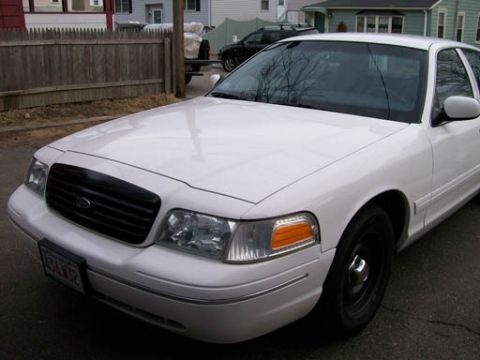 1999 Ford Crown Victoria - Front view of a white Ford Crown Victoria, likely a 1998 model, parked outdoors.