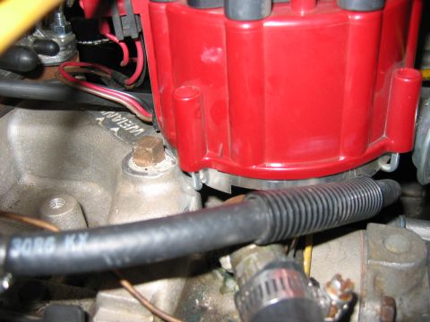 1985 Ford LTD Crown Victoria - A close-up view of engine components, including a red distributor cap and various hoses and wires.