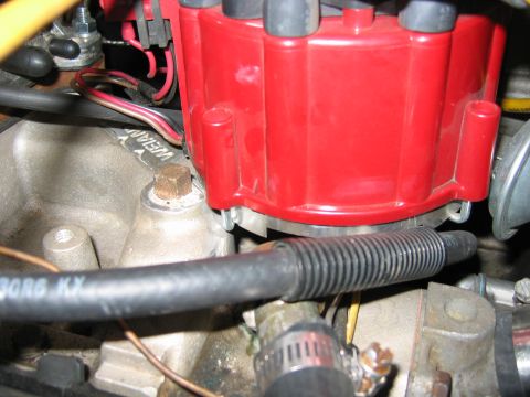 1985 Ford LTD Crown Victoria - Close-up view of an engine's red distributor cap and associated wiring.