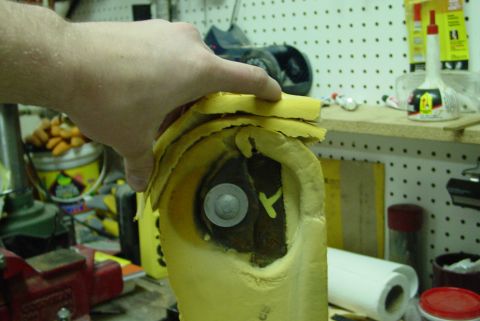 1993 Ford Bronco - Torn car seat foam padding is being held up, showing the interior structure and a bolt.