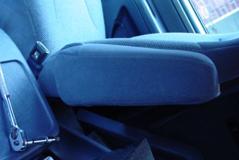 1993 Ford Bronco - Close-up view of a vehicle's interior, focusing on the armrest and seatbelt mechanism.