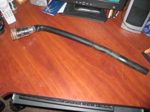 1991 Ford Bronco - A fuel filler neck part is shown on a wooden desk.