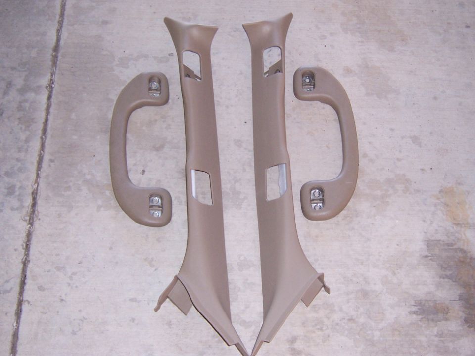 Tan interior pillar trim panels and grab handles on concrete floor