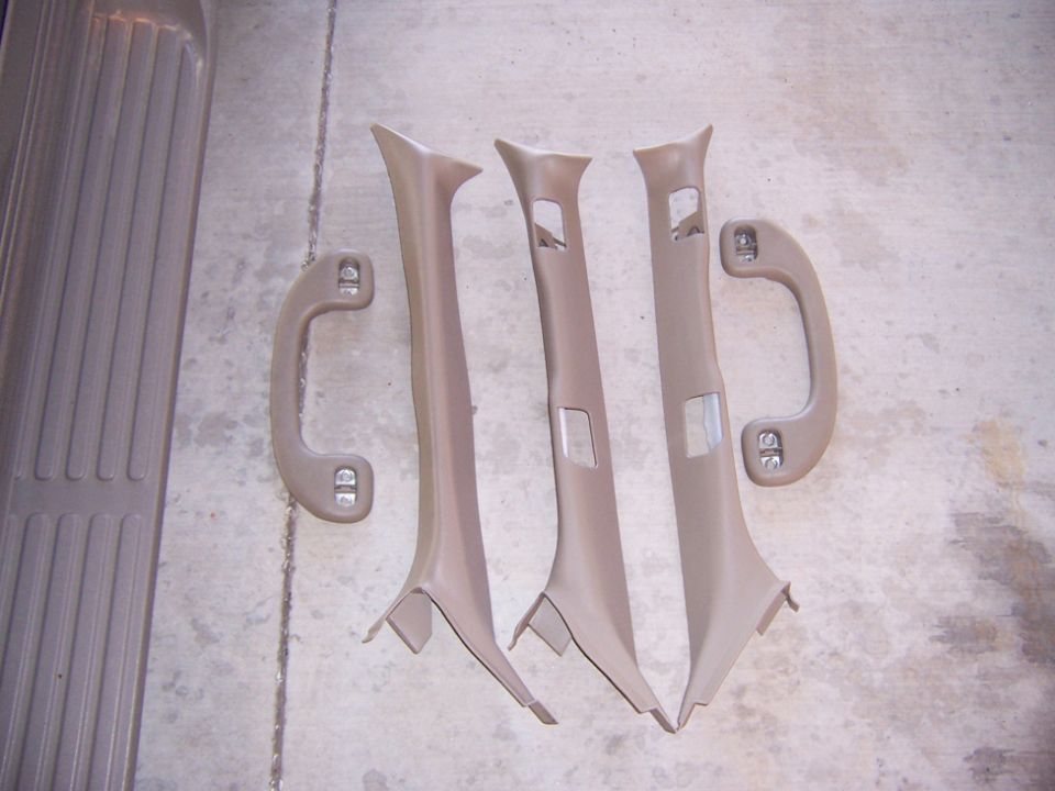 Tan interior pillar trim panels and grab handles on concrete floor
