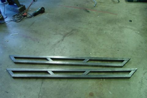 1993 Ford Bronco - Custom metal running boards are shown on a concrete floor with tools in the background.
