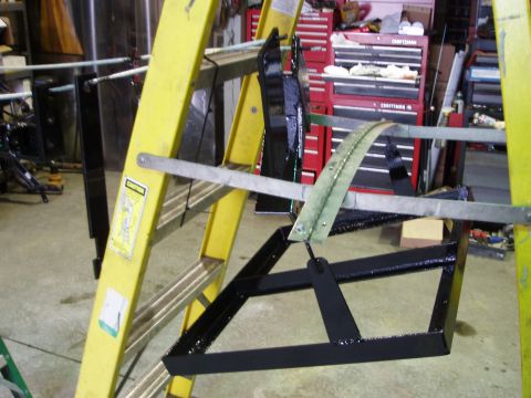 1979 Ford Bronco - Metal components are suspended from a yellow ladder in a workshop setting.