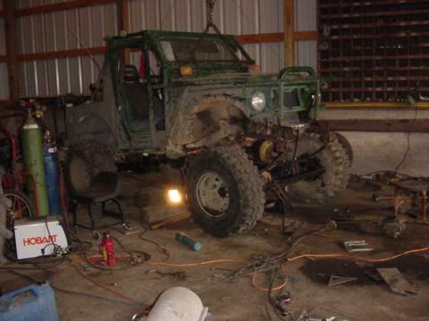 1992 Ford Bronco - An off-road vehicle is being worked on in a garage, with tools and equipment scattered around.