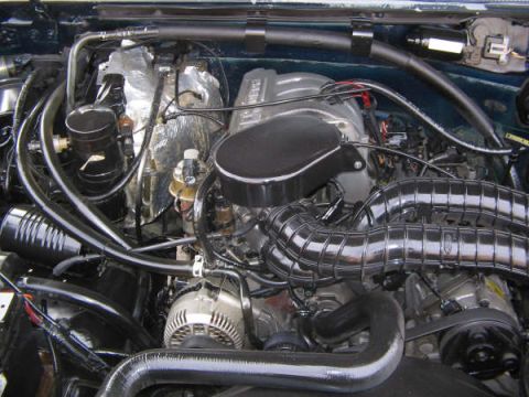 1995 Ford Bronco - Close-up view of a vehicle's engine bay, showing various components and hoses.