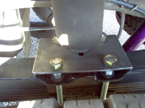 1995 Ford Bronco - Rear suspension component, likely an aftermarket shock mount, attached to leaf springs.