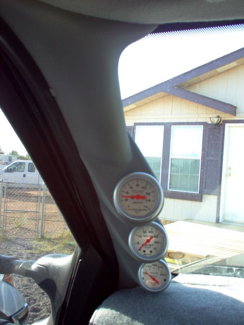 1995 Ford Bronco - Interior view showing a triple gauge pod mounted on the A-pillar, with visible readings on the gauges.