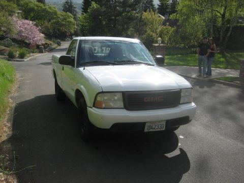 1995 Ford Bronco - Front view of a white GMC pickup truck parked on a residential street.