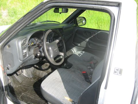 1995 Ford Bronco - The interior of a pickup truck shows gray seats and a black dashboard with a GMC logo on the steering wheel.