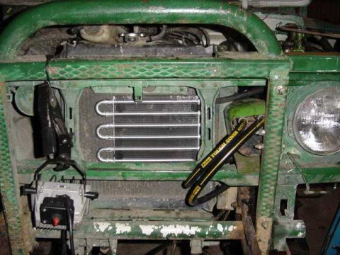 1992 Ford Bronco - Front view of a green vehicle showing its radiator and headlight. A hose with "Dana Evap Cover" text is visible.