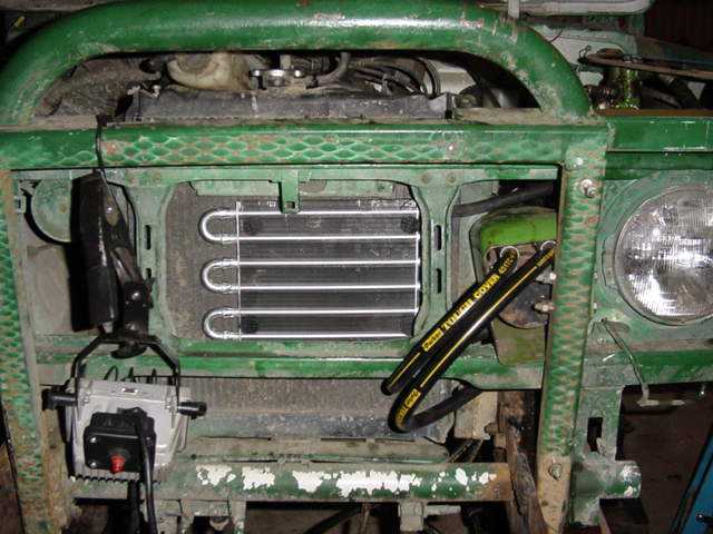 Green vehicle front end with exposed radiator and headlight. Text on hose reads "Dana Evap Cover"
