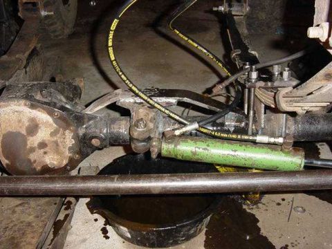 1992 Ford Bronco - Dana 44 axle with hydraulic steering assist cylinder and brake lines visible.