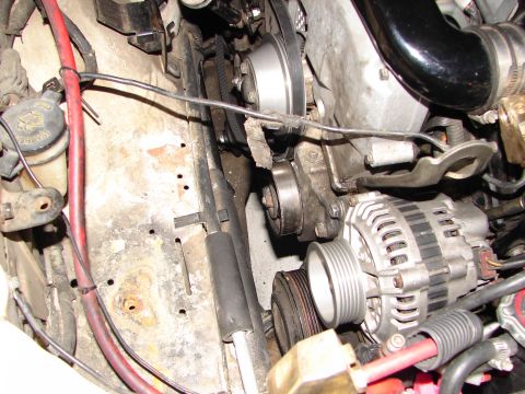 1992 Ford Taurus - Close-up view of engine components including the alternator, belts, and pulleys.