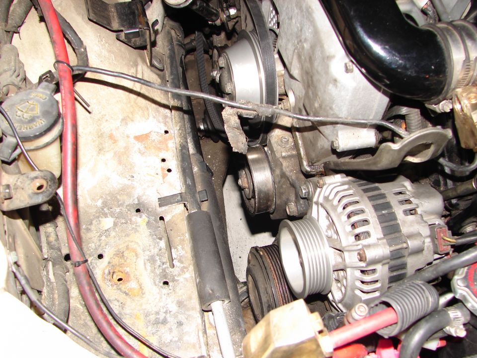 Engine compartment showing alternator, belts, and pulleys