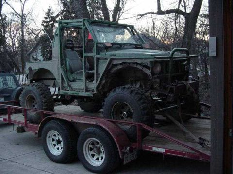1992 Ford Bronco - An off-road vehicle with a custom roll cage is loaded onto a trailer.