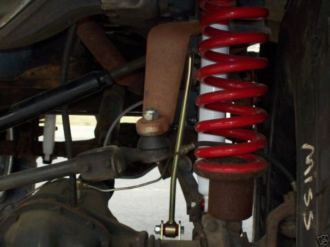 1991 Ford Bronco - Close-up view of vehicle suspension components, including red coil springs and rusty metal parts.