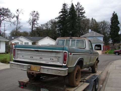 1996 Ford Bronco - This two-tone green and silver Ford pickup truck, likely from the late 1970s, is seen from the rear while on a trailer.
