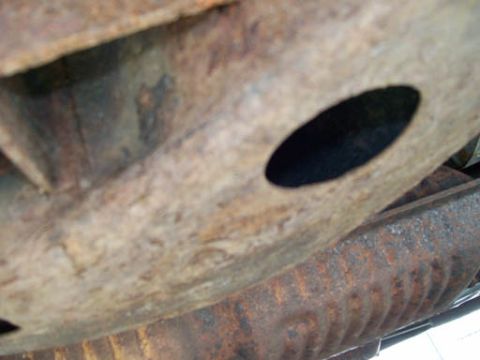1999 Ford Crown Victoria - Close-up view of heavily rusted vehicle frame and underbody parts, with a SuperMotors logo visible.