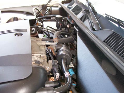 1999 Ford Crown Victoria - Close-up view of the engine compartment of a 1999 Ford Crown Victoria, revealing various mechanical parts and connections.