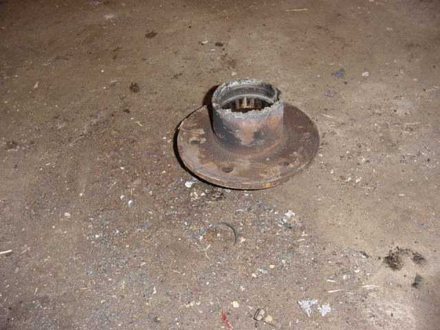 Rusted wheel hub with damaged bearing race on concrete floor