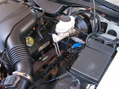 1999 Ford Crown Victoria - Close-up view of the engine bay components, including the air intake and brake system.