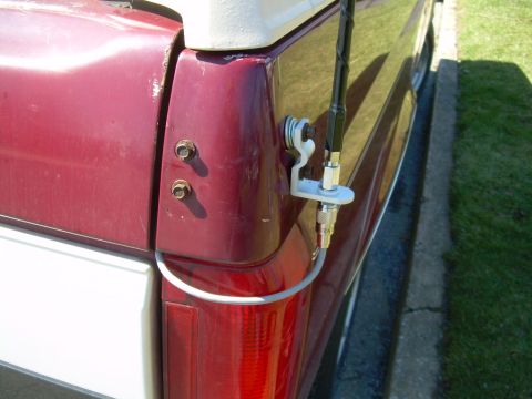 1992 Ford Bronco - Close-up of the rear side panel of a vehicle, an antenna mount and wiring.