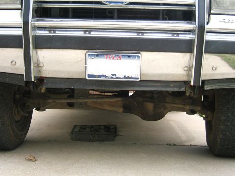 1991 Ford Bronco - Undercarriage view of a vehicle, showing the front tow hooks and suspension components.