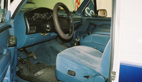 1996 Ford Bronco - The interior of a 1996 Ford Bronco features blue cloth seats and a dark dashboard with clear instrumentation.