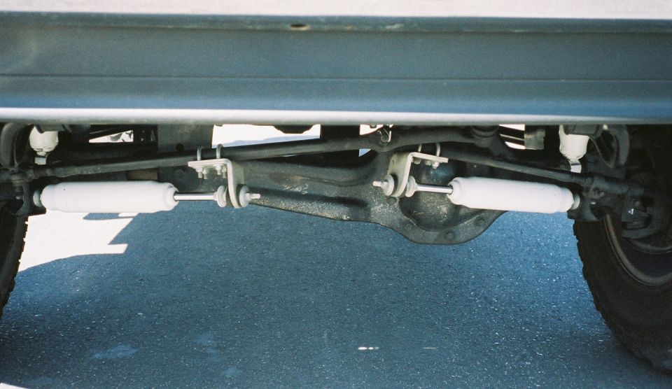 Rear leaf-spring suspension and axle under a silver vehicle