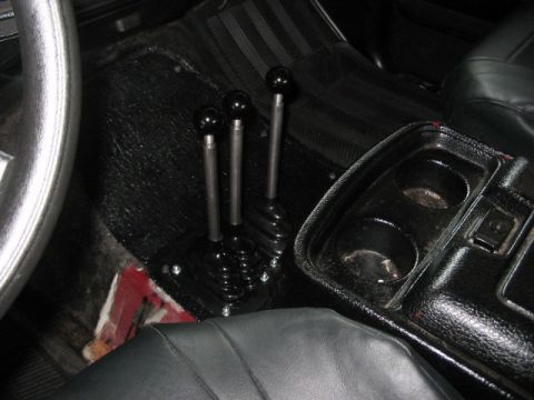 1991 Ford Bronco - Vehicle interior with three manual shifters and a center console.