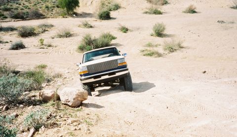 1996 Ford Bronco - This truck is navigating a rocky, off-road trail in a desert environment.