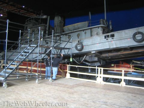 1990 Ford Bronco - Workers stand beside scaffold stairs leading up to a full-size tugboat prop on a soundstage backed by a blue screen.
