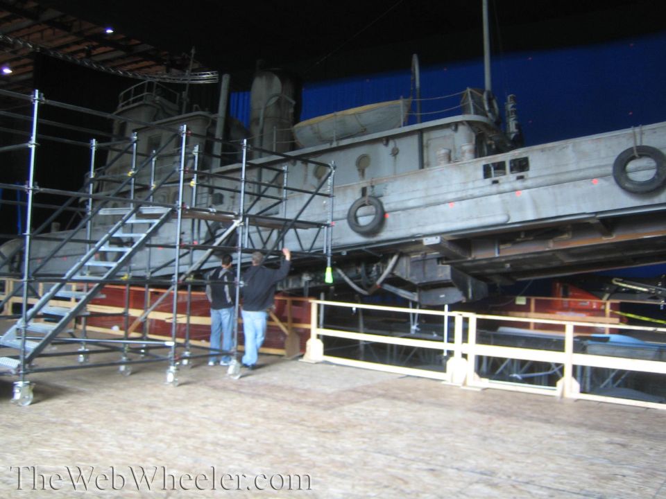 Large tugboat prop on a soundstage with scaffold stairs and a blue screen