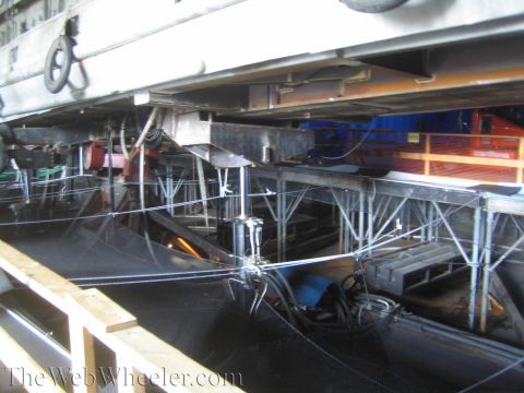 1990 Ford Bronco - View beneath a large soundstage prop showing steel I-beam scaffolding, cabling and hydraulic gear supporting the structure.