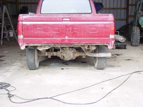 1992 Ford Bronco - Rear view of a red pickup truck, displaying its tailgate and undercarriage.