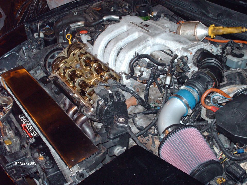Engine bay with V6 intake manifold, exposed camshafts, and aftermarket air filter. Date stamp reads 01/22/2005
