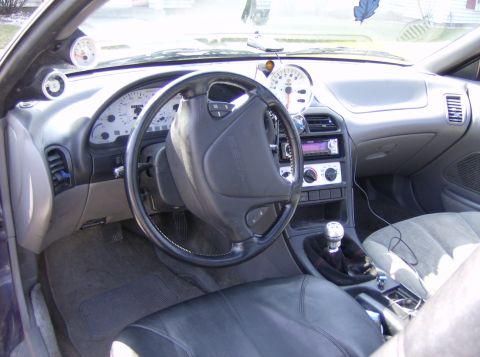 1996 Ford Probe - The dashboard features aftermarket gauges and a stereo system, with a manual transmission shifter visible.