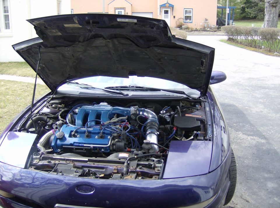 Open engine bay of a purple coupe with blue valve cover and cold-air intake