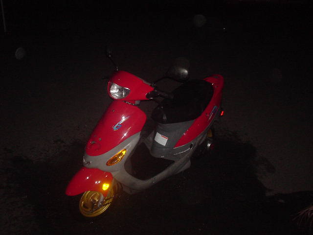 Red and silver motor scooter photographed at night