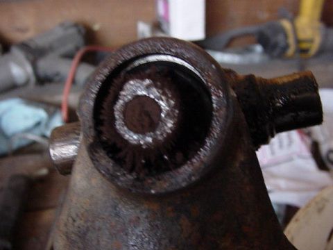 1992 Ford Bronco - Close-up view of a heavily rusted metal component, possibly a suspension or drivetrain part, with visible splines in the center.