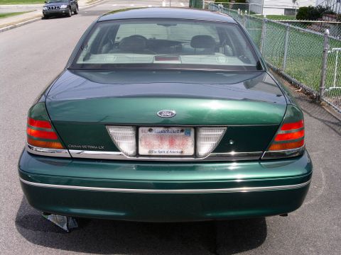 2001 Ford Crown Victoria - Rear view of a green 2001 Ford Crown Victoria LX, showing its distinctive taillights and chrome trim.