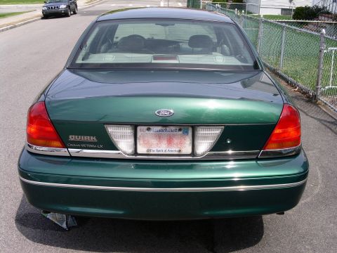 2001 Ford Crown Victoria - Green 2001 Ford Crown Victoria LX seen from the rear, with another vehicle in the background.