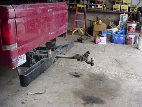 1992 Ford Bronco - Rear view of a red pickup truck bed with a trailer hitch attached.
