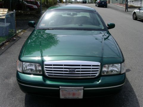 2001 Ford Crown Victoria - A green 2001 Ford Crown Victoria is shown from the front, parked on a residential street.
