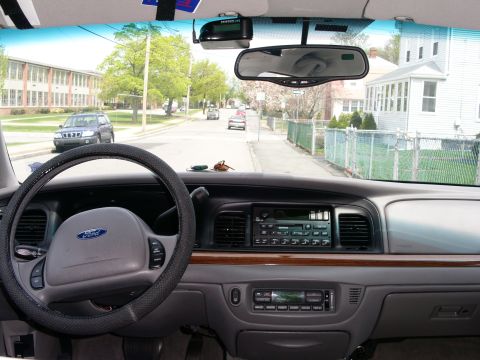 2001 Ford Crown Victoria - Dashboard view from the driver's seat of a 2001 Ford Crown Victoria, showing the steering wheel and center console.