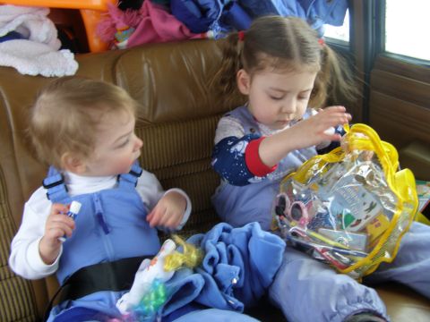 2000 Ford E350 - Children sit in the interior of a vehicle, surrounded by blankets and toys.